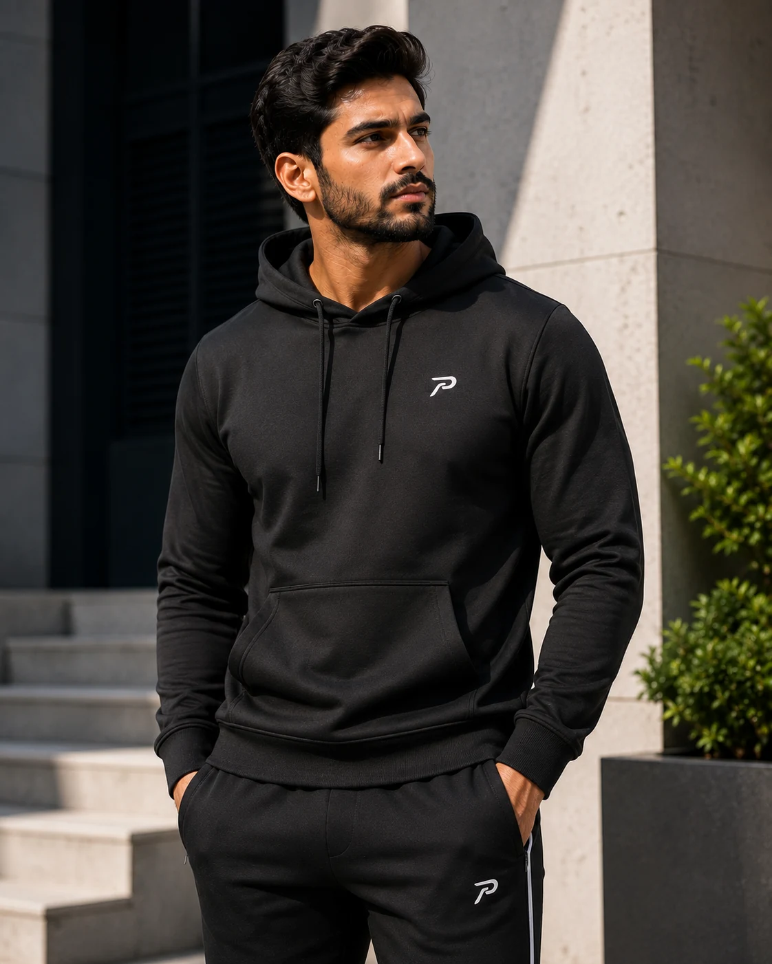 Black hoodie and joggers shown as layered sports and casual apparel